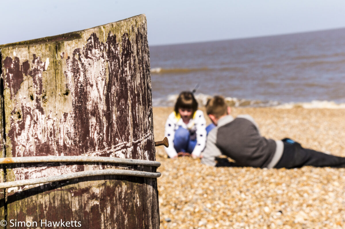 Dunwich Heath Suffolk pictures - A post in the foreground with a boy and girl playing in the background