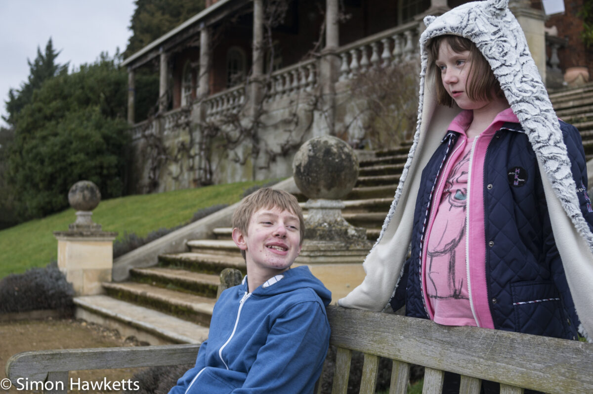 Pictures of Bennington Lordship - A boy sitting on a garden seat with a girl behind him