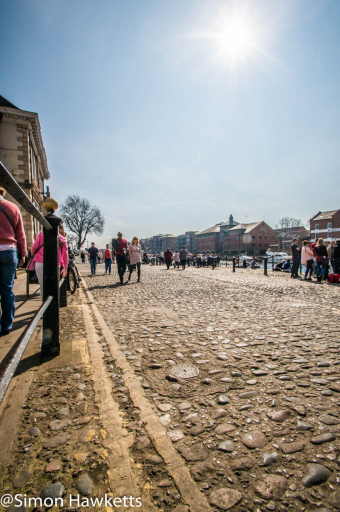 A cobbled street and a full sun by the Ouse in York