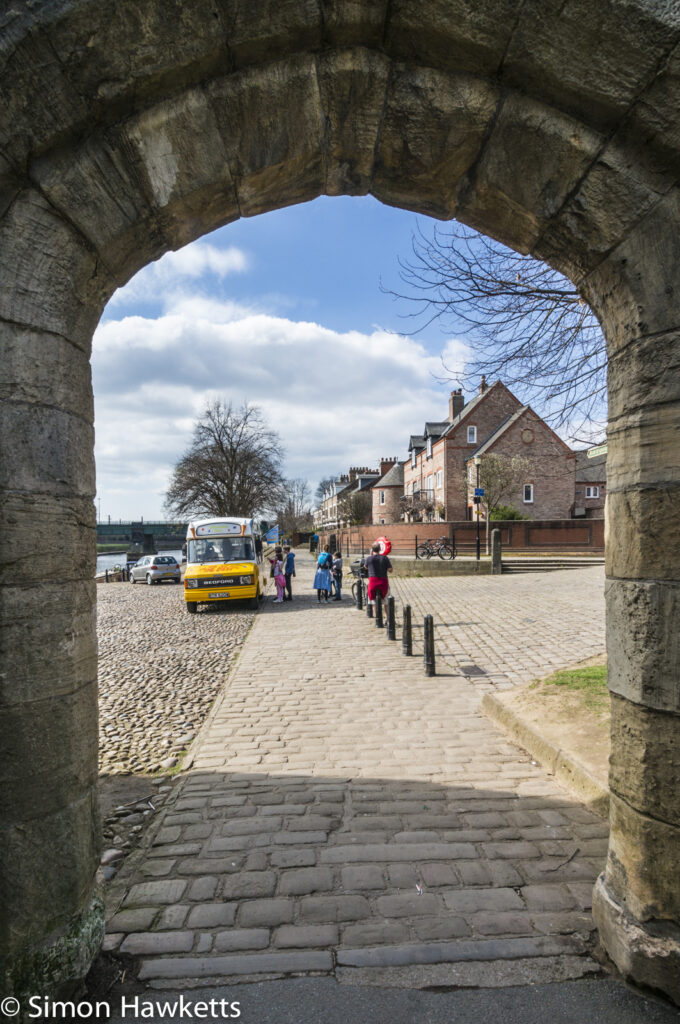 An archway with an Icecream van next to the river Ouse in York
