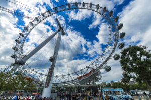 The London Eye against a blue sky with clouds