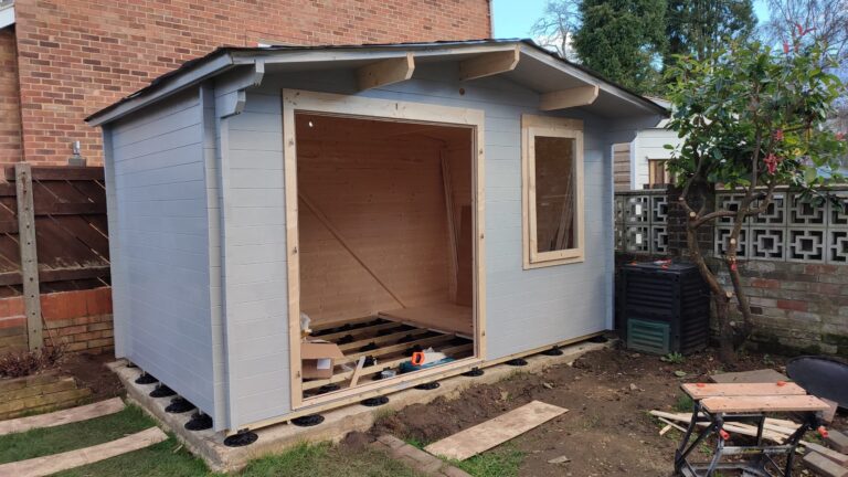 A picture of a Dunster House log cabin with grey paint applied.