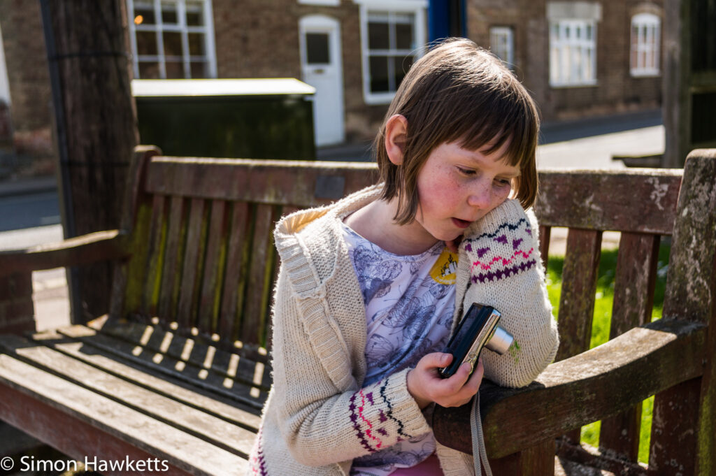 Pictures of Framlingham in Suffolk - A girl sitting on a bench with a camera